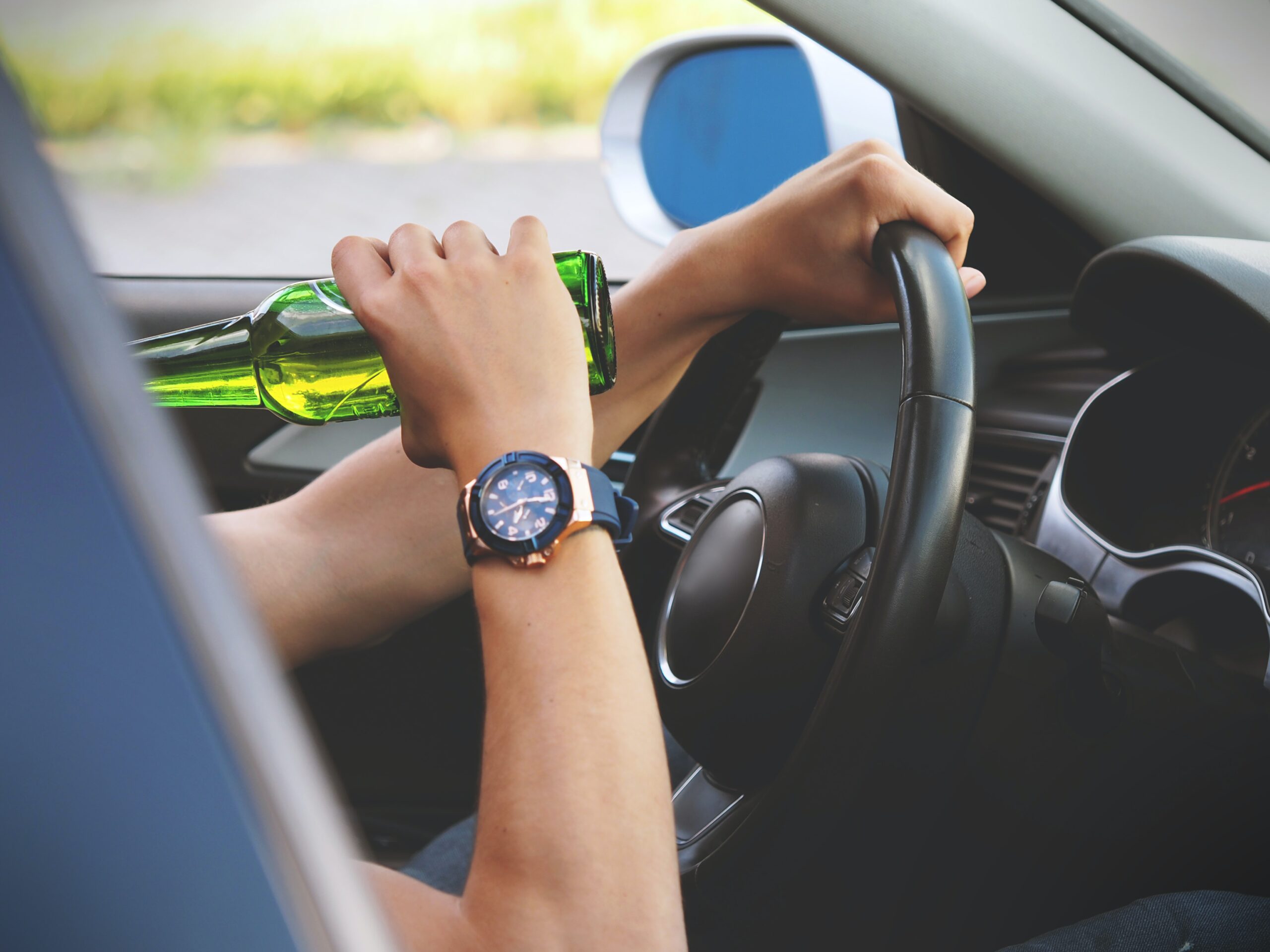 man drinking beer while driving