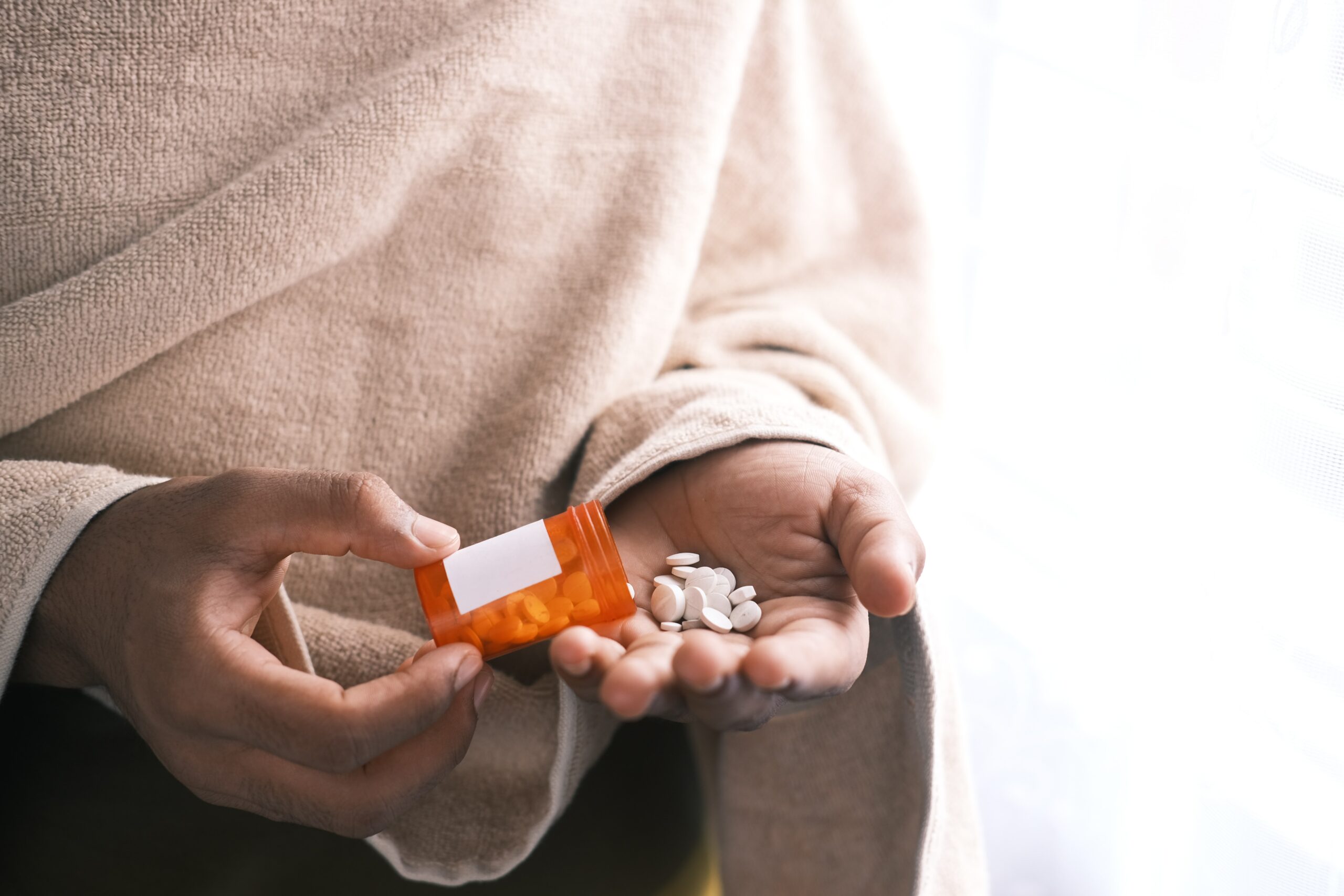 woman taking pills from container