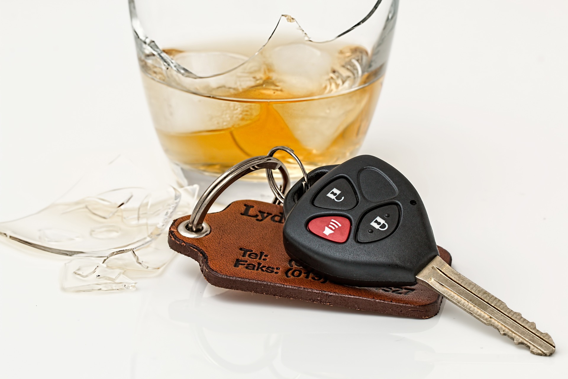 car keys next to broken glass of whisky