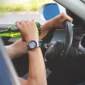 man drinking beer while driving car