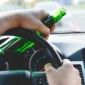 Person holding beer bottle while driving