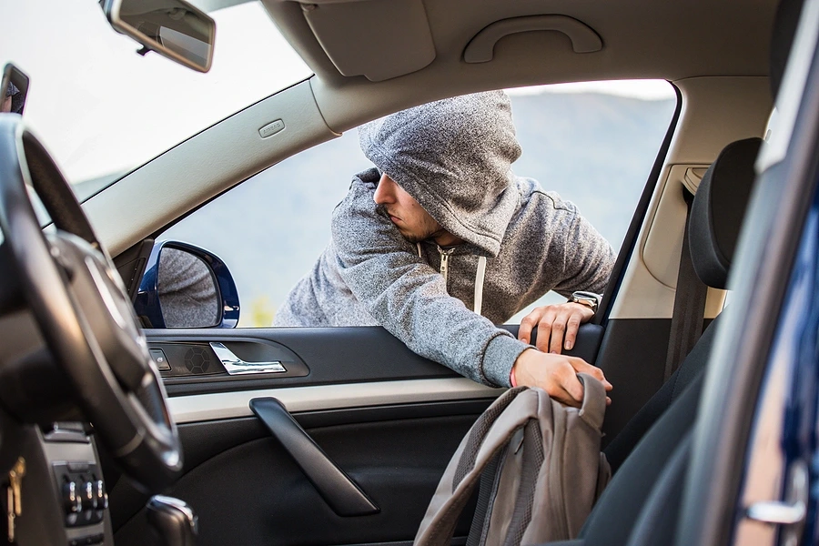 Hooded person reaching into car window